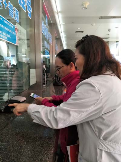 工作人员指导患者家属体验线上支付.jpg